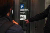 Es wird mit einem Finger auf verschiedene Mobilitätssymbole an einer Aufzugscheibe gezeigt.