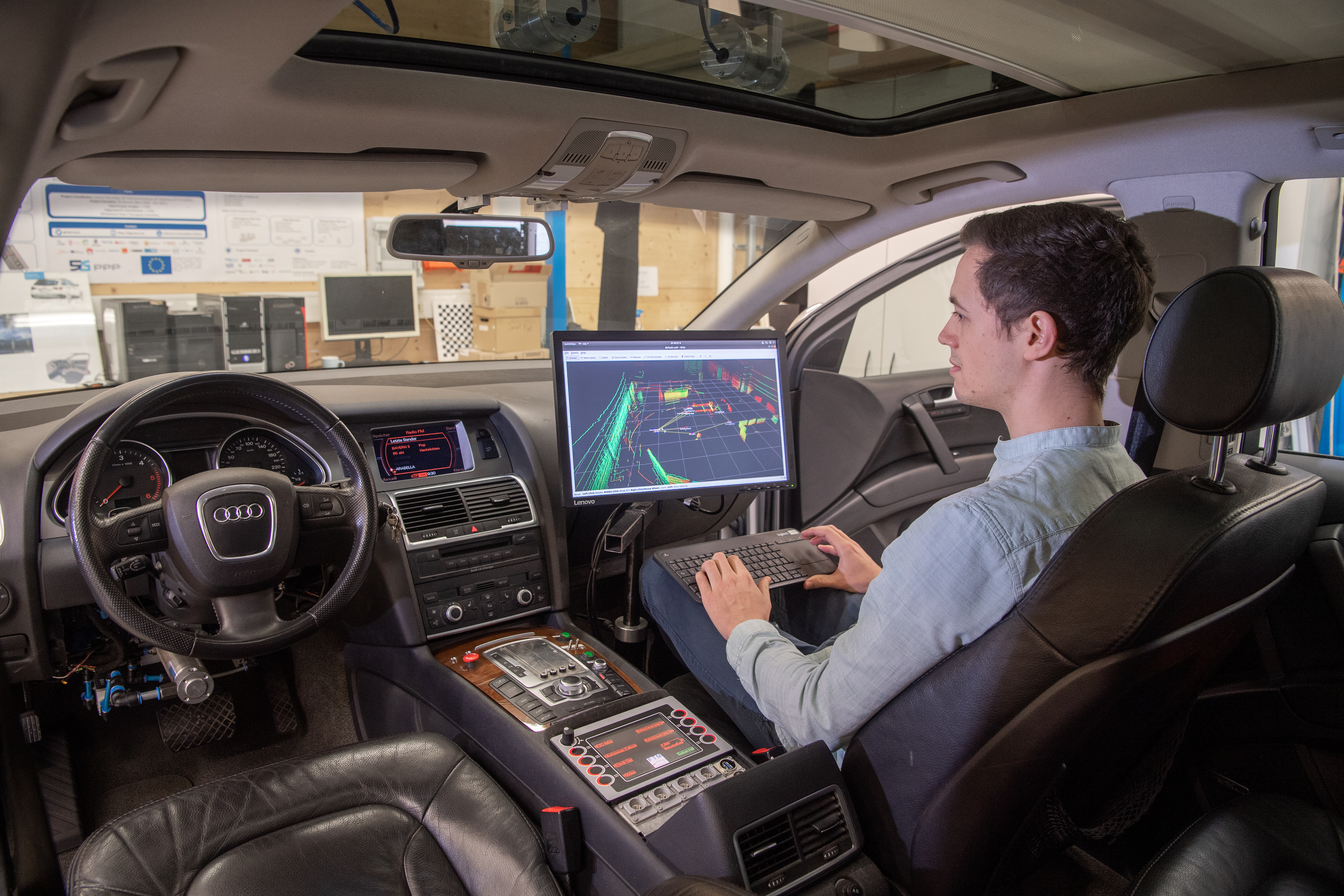 Teleoperated test vehicle with steering wheel for monitoring by a safety driver