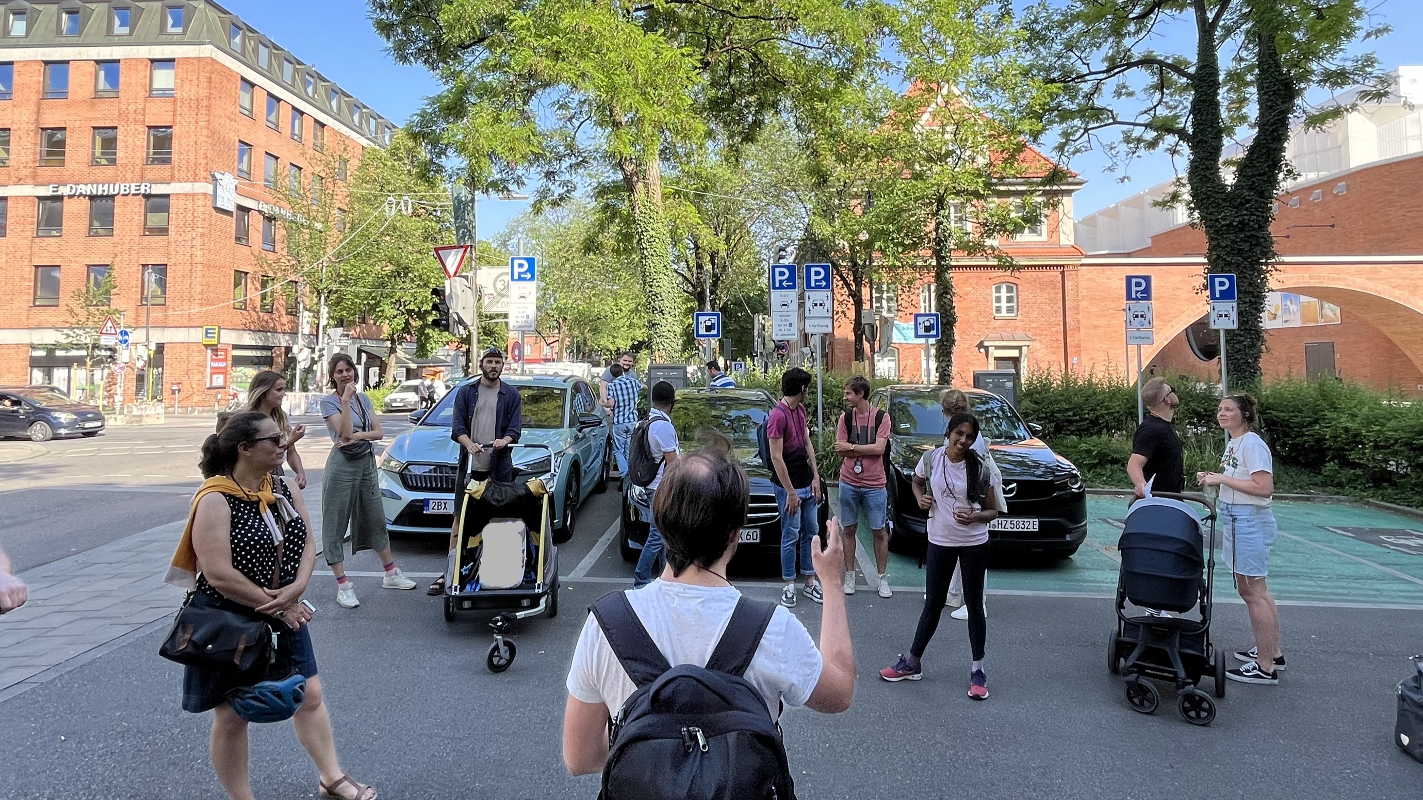 People stand in a car park and look around.